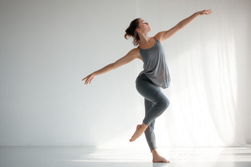 Frau praktiziert Fascial Dance Bewegungen für geschmeidige Faszien und mehr Beweglichkeit im hellen Fitnessstudio